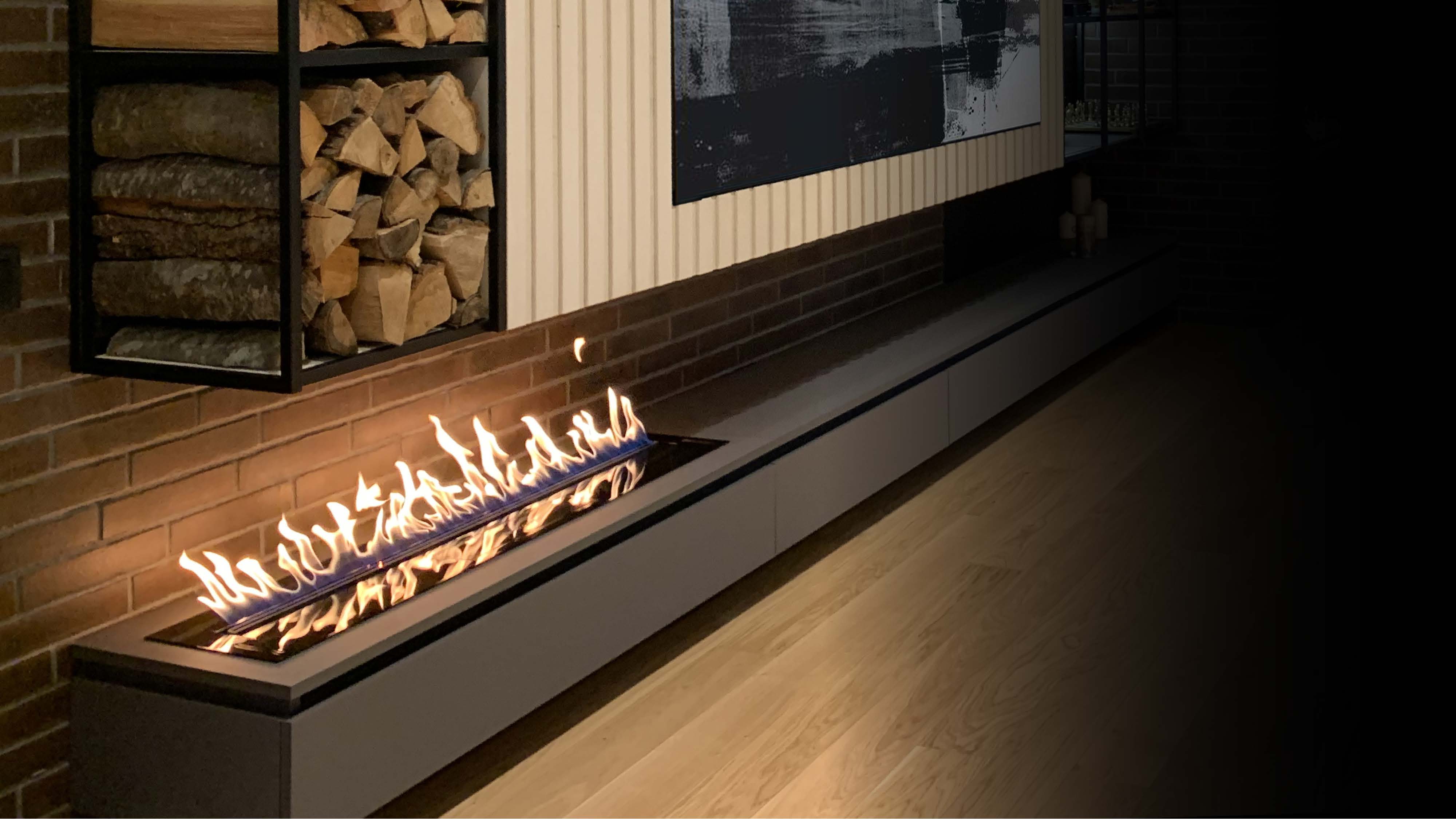 A long bioethanol flame integrated into dark cabinetry beneath shelving.
