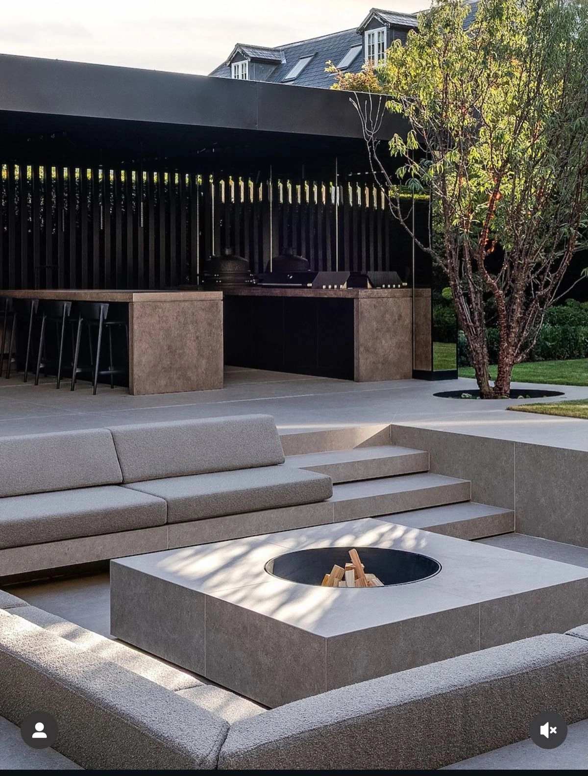 A rectangular fire pit set within an outdoor terrace and garden.